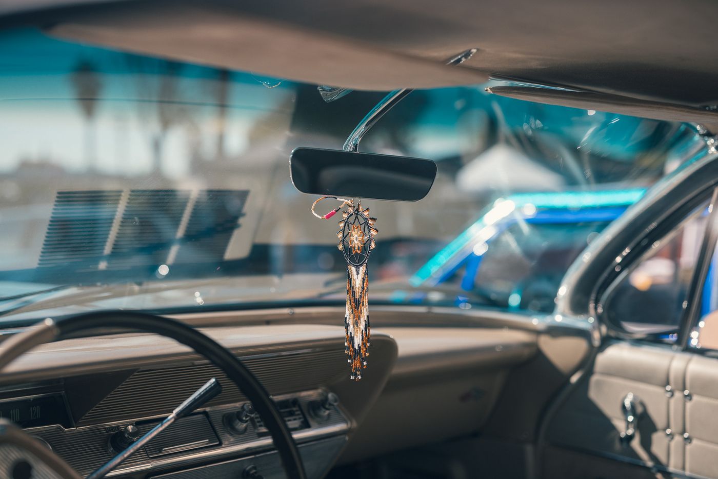 Hanging from the mirror.